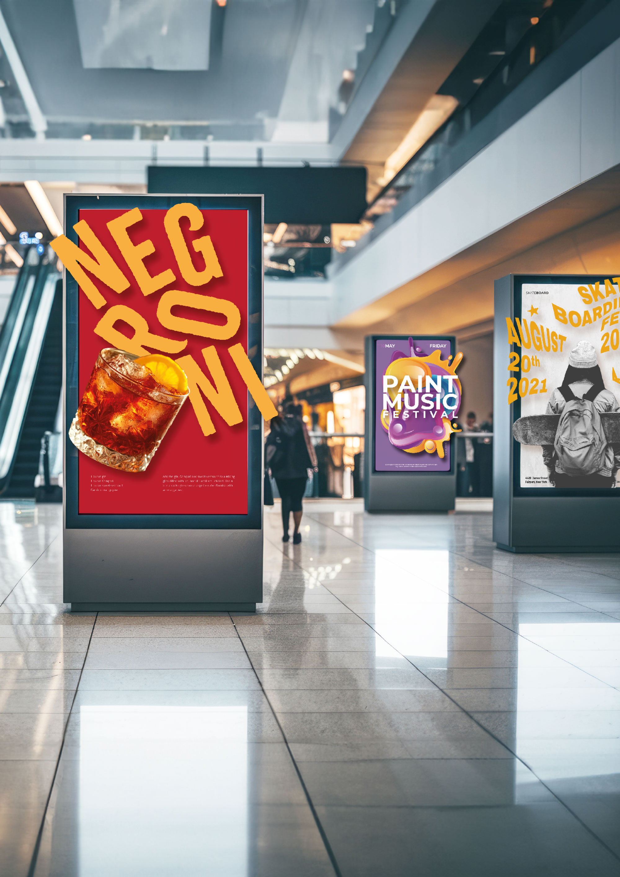 Werbetafeln in einem Einkaufszentrum zeigen Anzeigen für Negroni-Cocktail, Paint Music Festival und Skateboarding-Event im August 2021