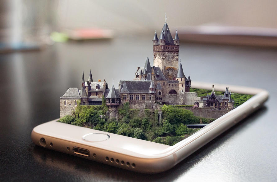 Historisches Schloss mit Türmen und Mauern, das aus dem Bildschirm eines Smartphones herausragt
